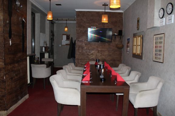 Iznajmljivanje lokala za proslave u Novom Sadu, dugi sto u restoranu Dedina Tajna sa modernim osvetljenjem i TV ekranom.