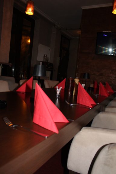 Privatni prostor za proslave u restoranu Dedina Tajna, sa dekorisanim stolom i udobnim stolicama.