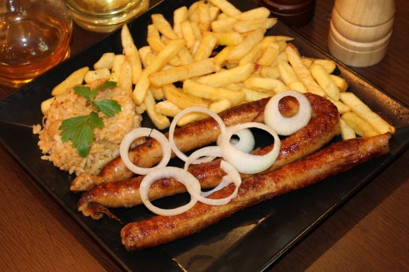 Roštilj kobasica sa pomfritom i lukom u restoranu Dedina Tajna Novi Sad