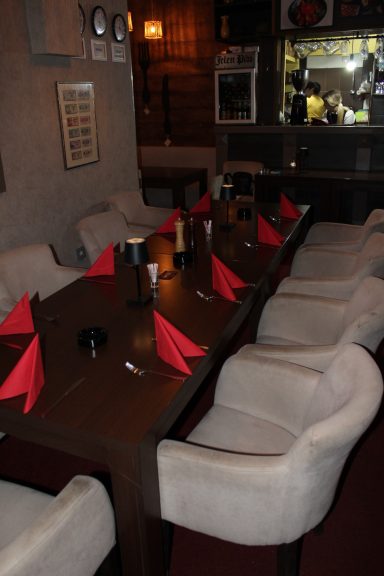 Sala za proslave u Novom Sadu, detalj stola sa crvenim salvetama i modernim dekorom.